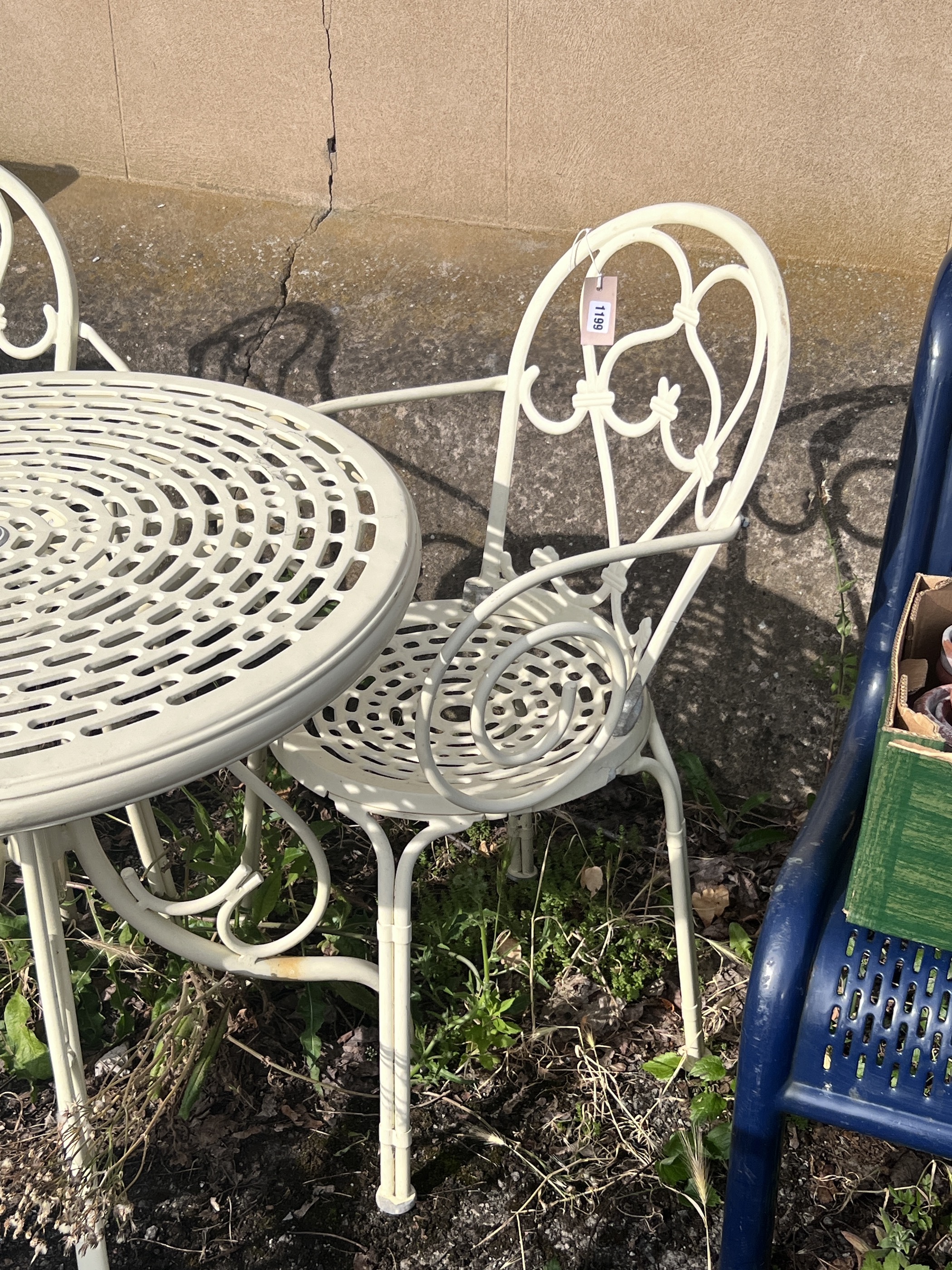 A circular aluminium garden table, diameter 74cm, height 73cm, and two elbow chairs